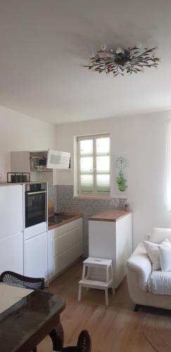 eine weiße Küche mit einem Sofa und einem Tisch in einem Zimmer in der Unterkunft Relax oasis near Split in Vranjic