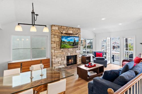 a living room with a couch and a fireplace at The Americana 4 bedroom with spa and bikes, seps to the beach in Huntington Beach