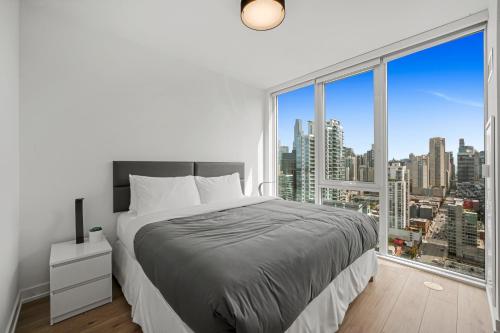 a white bedroom with a bed and a large window at Level Chicago River North in Chicago
