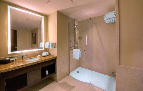 a bathroom with a shower and a sink and a tub at Hilton Garden Inn, Trivandrum in Trivandrum