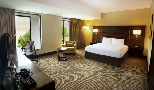 Cette chambre comprend un lit, un bureau et une chaise. dans l'établissement Hilton Garden Inn, Trivandrum, à Trivandrum