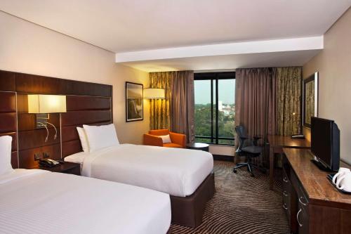 a hotel room with two beds and a television at Hilton Garden Inn, Trivandrum in Trivandrum