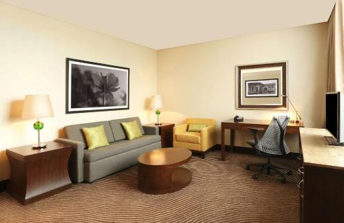 a hotel room with a couch and a desk at Hilton Garden Inn, Trivandrum in Trivandrum