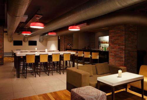 a restaurant with a bar with a long table and chairs at Hilton Garden Inn, Trivandrum in Trivandrum