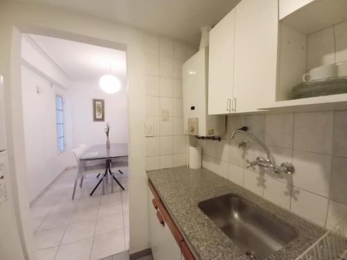 cocina con fregadero y mesa en Hermoso Apart Barrio Sur en San Miguel de Tucumán