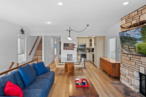 a living room with a blue couch and a fireplace at The Americana 4 bedroom with spa and bikes, seps to the beach in Huntington Beach
