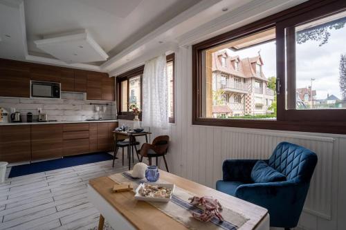 un salon avec un canapé bleu et une table dans l'établissement Deauville : magnifique studio en face du Casino !, à Deauville