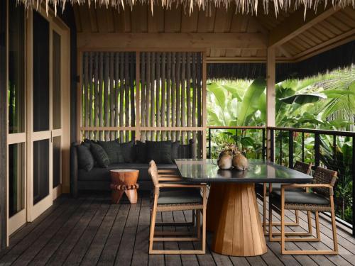 a patio with a table and chairs and a couch at Kona Village A Rosewood Resort in Kailua-Kona