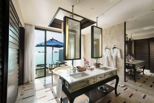a bathroom with a sink and a view of the ocean at Conrad Koh Samui in Taling Ngam Beach