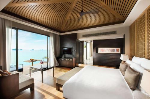 a bedroom with a bed and a view of the ocean at Conrad Koh Samui in Taling Ngam Beach