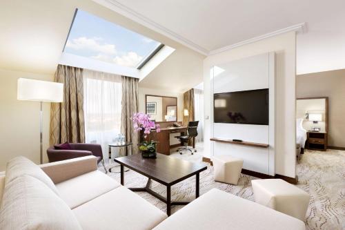 a living room with a white couch and a table at DoubleTree by Hilton Hotel & Conference Centre Warsaw in Warsaw