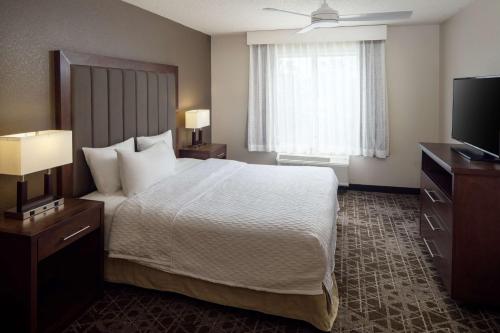 a hotel room with a large bed and a television at Homewood Suites by Hilton Wallingford-Meriden in Wallingford