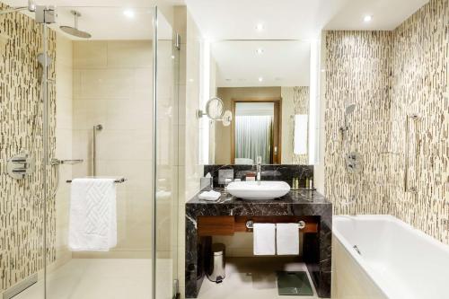a bathroom with a sink and a tub and a shower at DoubleTree by Hilton Hotel & Conference Centre Warsaw in Warsaw
