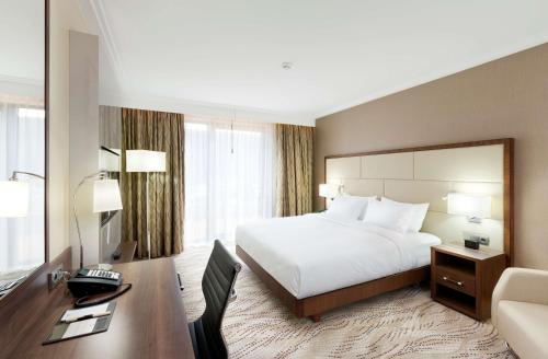 a hotel room with a bed and a desk with a computer at DoubleTree by Hilton Hotel & Conference Centre Warsaw in Warsaw