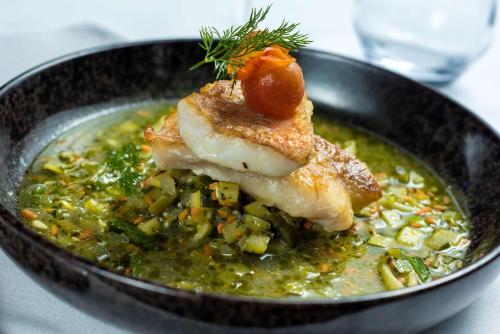 a bowl of food with a piece of fish on top at Hilton Evian Les Bains in Évian-les-Bains