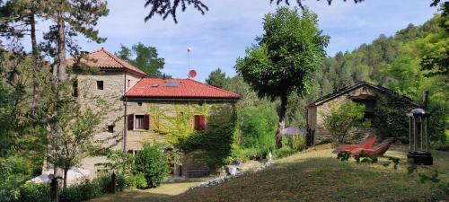 une maison avec un toit rouge à côté d'une cour dans l'établissement Porcaticcio, à Casola Valsenio