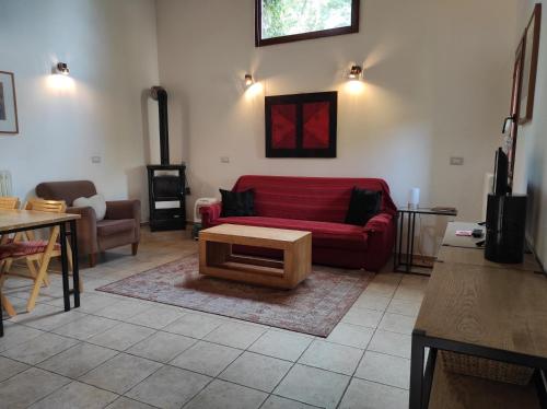a living room with a red couch and a table at Porcaticcio in Casola Valsenio