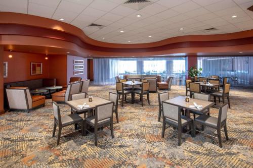 a restaurant with tables and chairs in a room at Embassy Suites Northwest Arkansas - Hotel, Spa & Convention Center in Rogers