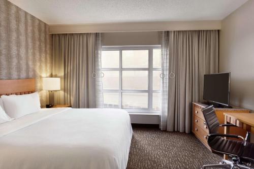 a hotel room with a large bed and a window at Embassy Suites Northwest Arkansas - Hotel, Spa & Convention Center in Rogers