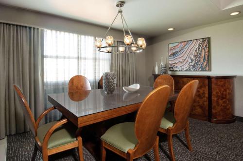 a dining room with a table and chairs at Embassy Suites Northwest Arkansas - Hotel, Spa & Convention Center in Rogers