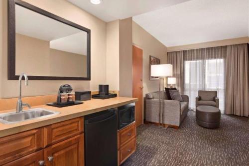 a hotel room with a sink and a bathroom at Embassy Suites Northwest Arkansas - Hotel, Spa & Convention Center in Rogers