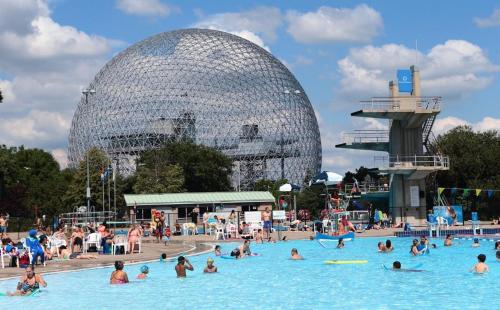 a group of people in a swimming pool with a large building at Luxueux - Deco moderne, Rosemont in Montréal