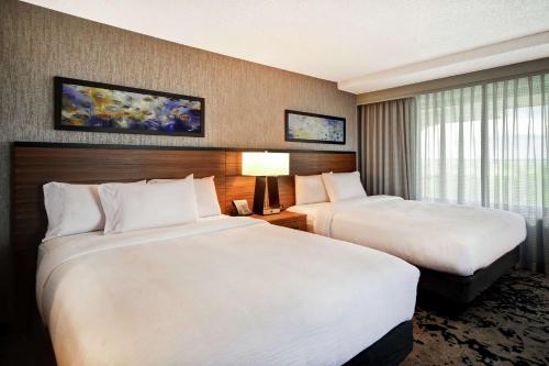 a hotel room with two beds and a window at Embassy Suites by Hilton Omaha Downtown Old Market in Omaha