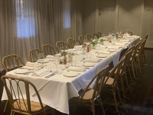 a long table with chairs and white table cloth at Links House in Bowral
