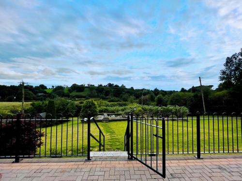 une porte en fer noir avec un champ vert derrière elle dans l'établissement Quiet self-catering holiday home with surrounding lakes, à Bailieborough