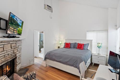 a bedroom with a bed and a fireplace at The Americana 4 bedroom with spa and bikes, seps to the beach in Huntington Beach