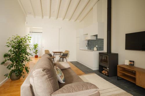 a living room with a couch and a flat screen tv at ENTRE MUROS - Turismo Rural - Casa com jardim e acesso direto ao mar in Ribeira Grande