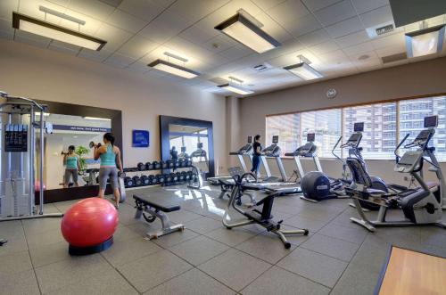 a gym with cardio equipment and people in the background at Hampton Inn & Suites by Hilton Miami Downtown/Brickell in Miami