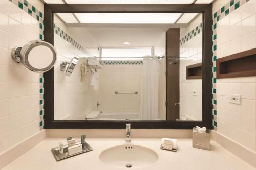 龐塞的住宿－龐塞希爾頓度假酒店，一间带水槽和镜子的浴室