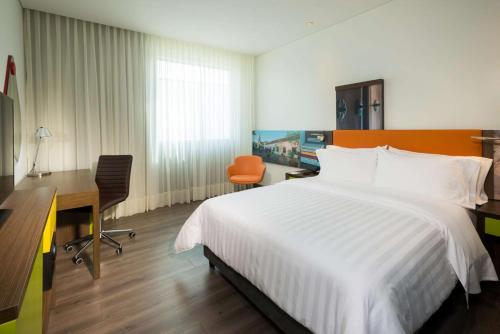 a hotel room with a bed and a desk and a desk at Hampton By Hilton Valledupar in Valledupar