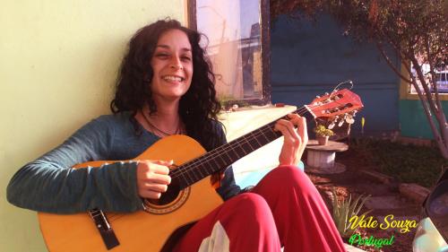 a woman holding a guitar in her lap at Hostel Posada de Gallo in Arica