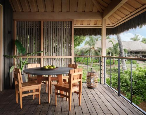 a wooden porch with a table and chairs on it at Kona Village A Rosewood Resort in Kailua-Kona