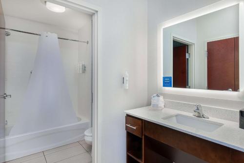 a bathroom with a sink and a shower with a mirror at Homewood Suites by Hilton Atlanta Perimeter Center in Atlanta