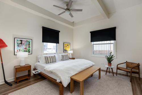 a white bedroom with a bed and two windows at The Lumber Baron's Mansion: 2 King Suites, 2.5BA + Gym in Detroit