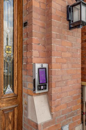 a pay phone on a brick wall next to a door at The Lumber Baron's Mansion: 2 King Suites, 2.5BA + Gym in Detroit