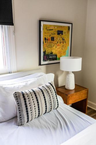 a bedroom with a bed with a lamp and a picture at The Lumber Baron's Mansion: 2 King Suites, 2.5BA + Gym in Detroit