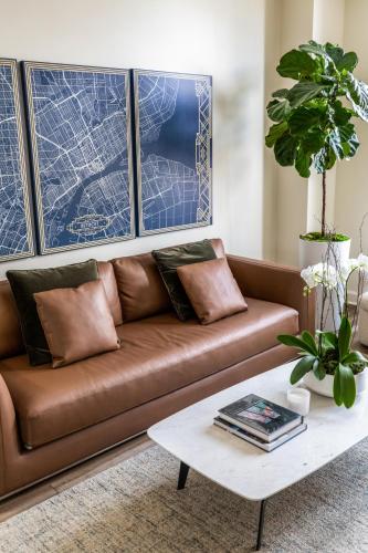 a brown couch in a living room with a coffee table at The Lumber Baron's Mansion: 2 King Suites, 2.5BA + Gym in Detroit