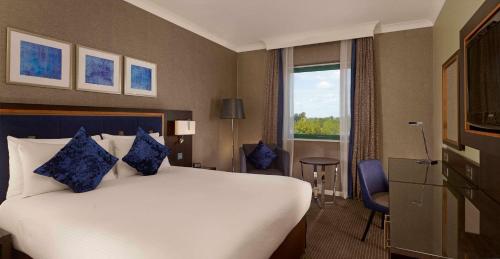 a hotel room with a large bed and a window at DoubleTree by Hilton Woking in Woking