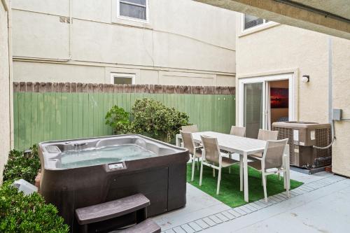 a hot tub in a yard with a table and chairs at The Americana 4 bedroom with spa and bikes, seps to the beach in Huntington Beach