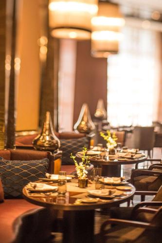 a restaurant with tables and couches and chairs at Conrad Pune in Pune