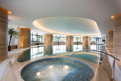 a swimming pool in a building with a hot tub at Hilton Zhoushan in Zhoushan