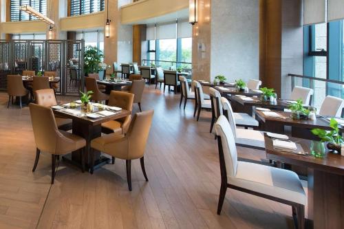 a dining room with tables and chairs in a restaurant at Hilton Zhoushan in Zhoushan