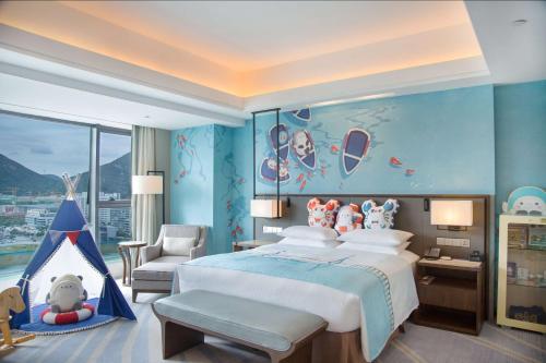 a bedroom with a large bed with a blue wall at Hilton Zhoushan in Zhoushan