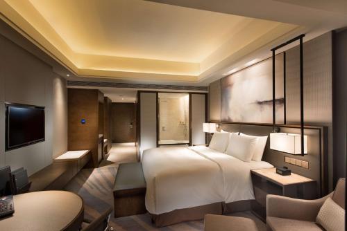 a hotel room with a bed and a desk at Hilton Zhoushan in Zhoushan