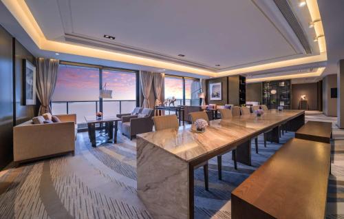 a large dining room with a long table and chairs at Hilton Zhoushan in Zhoushan