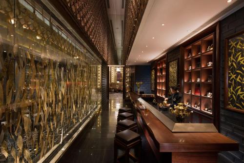 a wine tasting room with wine bottles on the wall at Conrad Pune in Pune